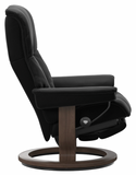 Black recliner chair with wooden base.