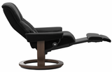 Black recliner chair with wooden base.