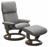 Gray Stressless recliner chair with matching ottoman on a white background